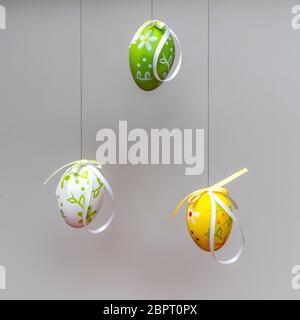 some colorful and decorated Easter eggs hanging by a thread Stock Photo