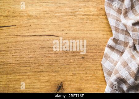 Checkered tablecloth over wooden table. Frame with checkered napkin on wooden background. Stock Photo