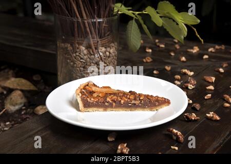 Honey and walnut tart with orange served in a white plate. Stock Photo
