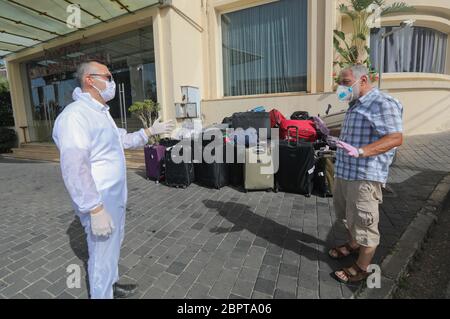 Beirut, Lebanon. 19th May, 2020. A worker gives instructions to a man returning from abroad in front of a hotel in Beirut, Lebanon, on May 19, 2020. Lebanon's number of COVID-19 infections increased on Tuesday by 23 cases to 954, while the death toll remained unchanged at 26, the National News Agency reported. Credit: Bilal Jawich/Xinhua/Alamy Live News Stock Photo