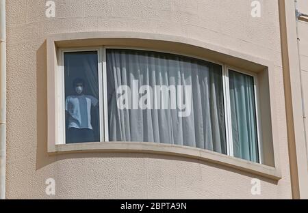 Beirut, Lebanon. 19th May, 2020. A man returning from abroad looks out from a window of a hotel in Beirut, Lebanon, on May 19, 2020. Lebanon's number of COVID-19 infections increased on Tuesday by 23 cases to 954, while the death toll remained unchanged at 26, the National News Agency reported. Credit: Bilal Jawich/Xinhua/Alamy Live News Stock Photo