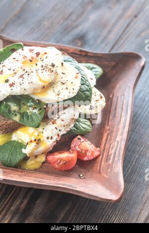 Sandwich with poached eggs, mozzarella, spinach and cherry tomatoes Stock Photo