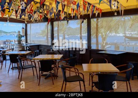 May 2020 - Normally busy, the bar mascot of the Sint Maarten Yacht Club Bar & Restaurant is alone while it is closed for the Covd-19 Pandemic Stock Photo
