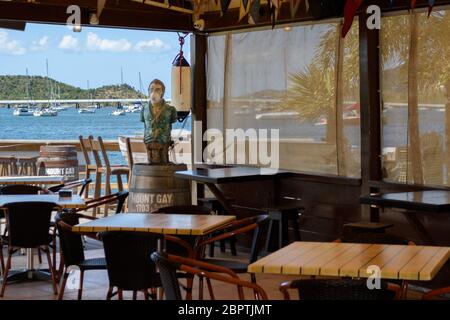 May 2020 - Normally busy, the bar mascot of the Sint Maarten Yacht Club Bar & Restaurant is alone while it is closed for the Covd-19 Pandemic Stock Photo