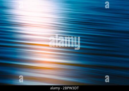Sunset on the sea at twilight times. Abstract background in dark blue and soft pink colors. Line art, motion blur, calm, tranquil scene. Stock Photo