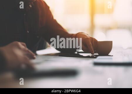 Closeup image of a man using and touching on tablet pc screen on the table Stock Photo