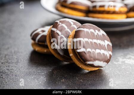 Sweet dessert with chocolate cream and chocolate icing on black kitchen table. Stock Photo