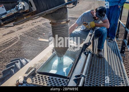 Swift Current, SK/Canada- May 15, 2020: Young farmer loading fertilizer into the Bourgault air drill for seeding in Saskatchewan, Canada Stock Photo