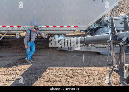 Swift Current, SK/Canada- May 15, 2020:  Farmer loading fertilizer from the Super-B into the Bourgault auger for seeding in Saskatchewan, Canada Stock Photo