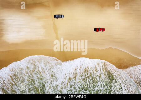 Two cars driving along Seventy Five Mile Beach on famous Fraser Island. Stock Photo