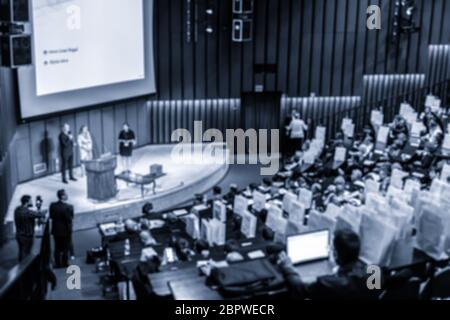 Defocused image of speakers giving a talk at business meeting Stock Photo