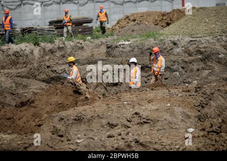 Bucharest, Romania - May 14, 2020: Asian construction workers on a construction site in Bucharest. Stock Photo