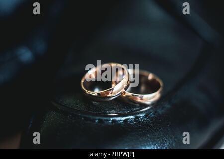 Close up of wedding rings on a black leather shoe Stock Photo