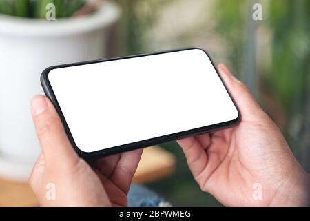 Mockup image of hands holding black mobile phone with blank screen Stock Photo