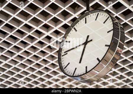 Modern clock with dial on structured wall background in black and white with chrome Stock Photo