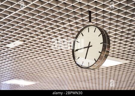 Modern clock with dial on structured wall background in black and white with chrome Stock Photo