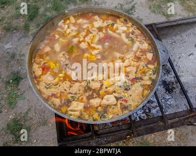 Bograch. Soup with paprika, meat, bean, vegetable, dumpling. Traditional Hungarian Goulash in cauldron. Meal cooked outdoors on an open fire Stock Photo