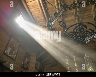 The rays of the sun make their way through the windows and cracks of the Orthodox church on the throne and sacred objects Stock Photo