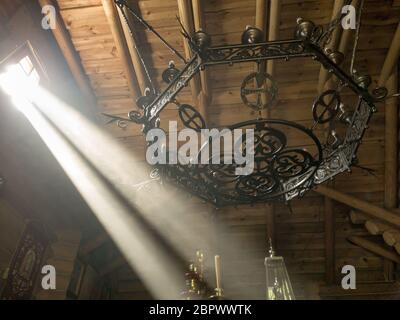 The rays of the sun make their way through the windows and cracks of the Orthodox church on the throne and sacred objects Stock Photo