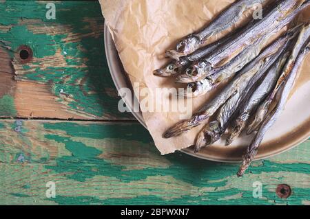 Dried salted capelin on vintage wooden background, top Stock Photo