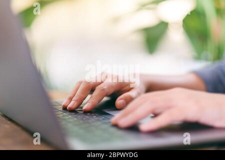 Closeup image of hands using and typing on laptop computer keyboard on the table Stock Photo