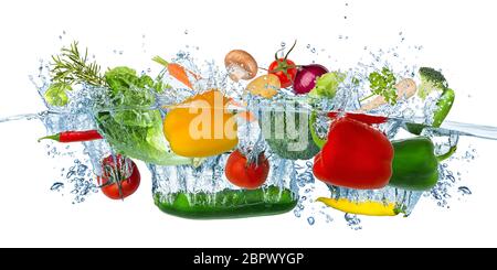 fresh vegetables splashing into blue clear water splash healthy food diet freshness concept isolated on white background Stock Photo