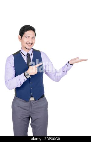 Young asian businessman pointing his open palm posing isolated over white background Stock Photo