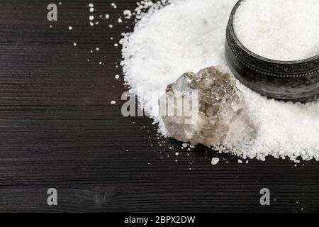 top view of vintage silver salt cellar , rough natural Halite mineral and grained Rock Salt close up on dark brown wooden board Stock Photo