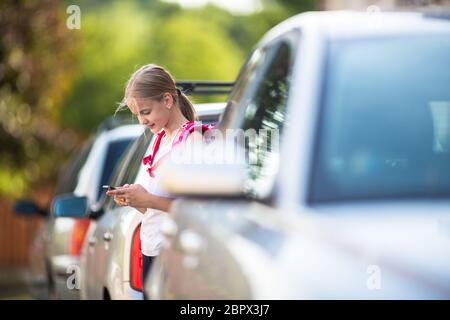 Cute little girl going home from school, looking well before crossing the street Stock Photo