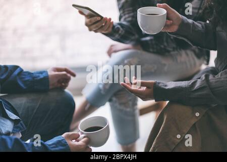 People using phone, talking and drinking coffee together Stock Photo