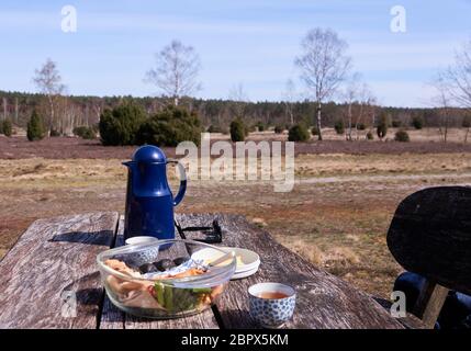 Picnic in the heath on a rustic wooden table Stock Photo