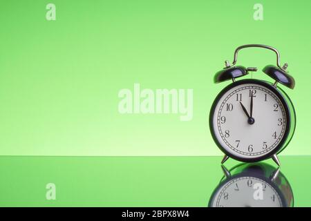 Alarm Clock on green background with selective focus and crop fragment. Copy space and business concept Stock Photo