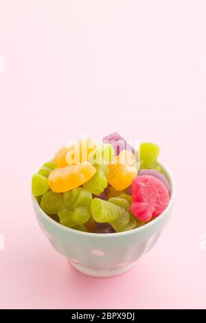 Fruit jelly candies in bowl on colorful background. Stock Photo