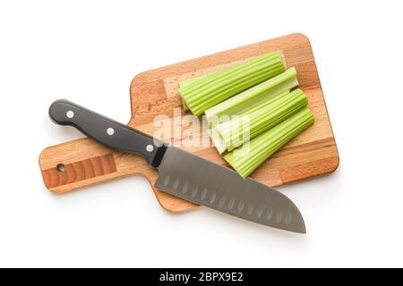 Celery sticks on cutting board. Cutting celery stalks and knife isolated on white background. Stock Photo