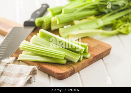 Celery sticks. Cutting celery stalks on cutting board. Stock Photo