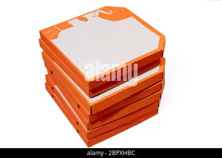 Close up of carton orange boxes for pizza isolated on white studio background with copyspace. Fast and traditional food and nutrition, delivery packing, boxes for shipping, transportation. Stock Photo
