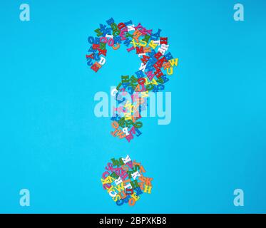 question mark figure from small multicolored wooden letters of the English alphabet on a blue background Stock Photo