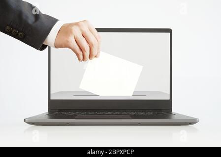 Voting Online Concept. Man Putting a Ballot into a Laptop. Stock Photo