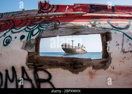 The Telamon (Temple Hall) shipwreck off Lanzarote at Arrecife viwed through a gap in the remains of an old fishing boat. . Stock Photo