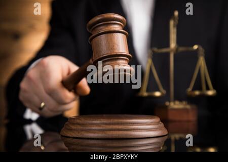 Justice and law concept, Male judge in a courtroom striking the gavel Stock Photo