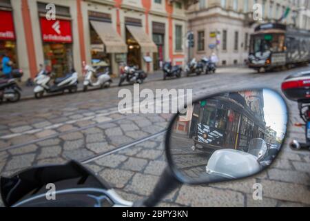 City tram passing on motorcycle mirror on Via Alessandro Manzoni, Milan, Lombardy, Italy, Europe Stock Photo