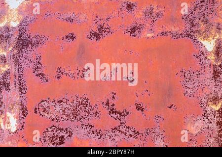 rusty iron wall with cracked red paint and stains Stock Photo