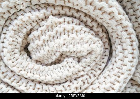 close-up of roll a white knitted plaid, soft selective focus. Stock Photo