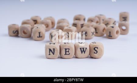 NEWS inscription on wooden alphabet over white background with selective focus Stock Photo