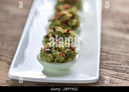 Bacon guacamole deviled eggs Stock Photo