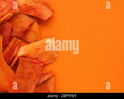 Dried organic papaya slices on an orange studio background, healthy food concept, view from above, space for text Stock Photo