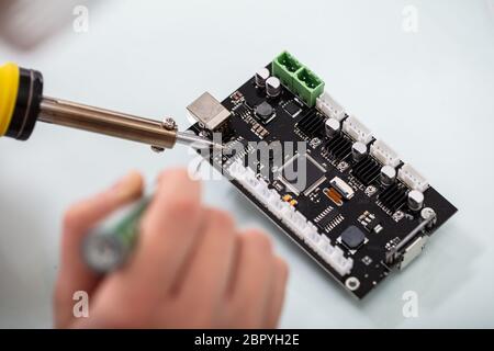 Female Engineer Or Tech Repairs Electronic Device In Hardware Repair Shop Stock Photo