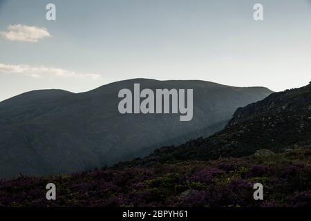 Rays of light pas through mountain hills when sun is setting down. Landscape view. Good lighting at sunset. Stock Photo