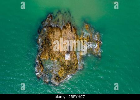 Drone view of a small offshore lighthouse located on a small, rocky ...