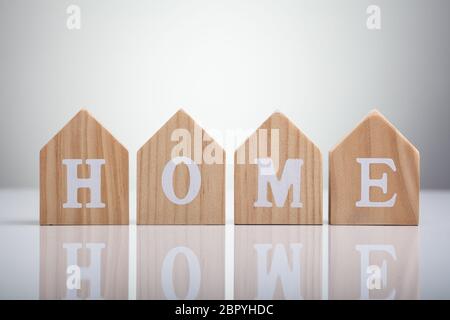 Close-up Of Home Word Written On Wooden Houses Over Desk Stock Photo